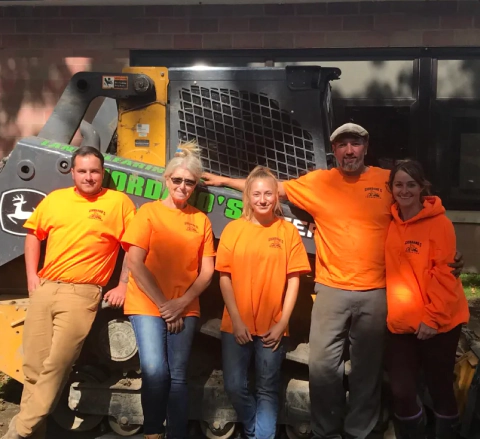 giordano employees posing in front of skid steer